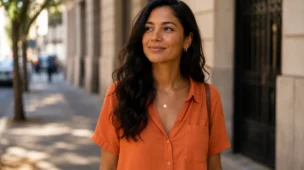 Mulher madura sorrindo com leveza em ambiente claro, representando confiança em si mesma no dia a dia
